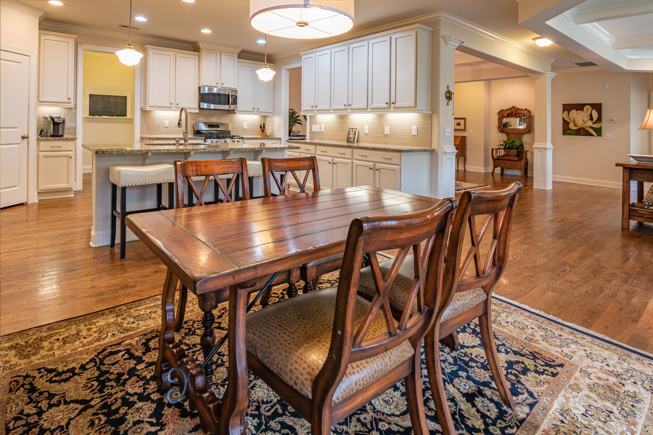 Classic dining room featuring a wooden table, chairs, and a gourmet kitchen setup.